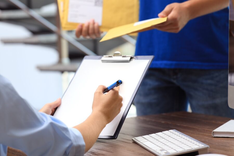 Woman signs for certified mail by P&C insurance carrier. | WaterStreet Company